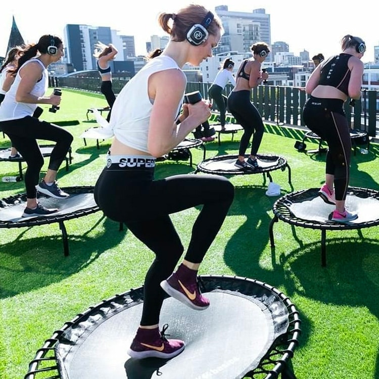 jumper Clase de jumping fitness al aire libre con auriculares inalámbricos
